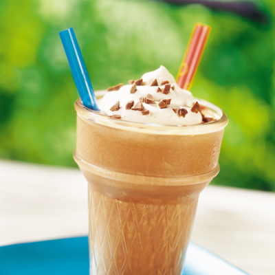 Photograph of tall iced coffee with whipped cream, chocolate shavings, and blue and red straws