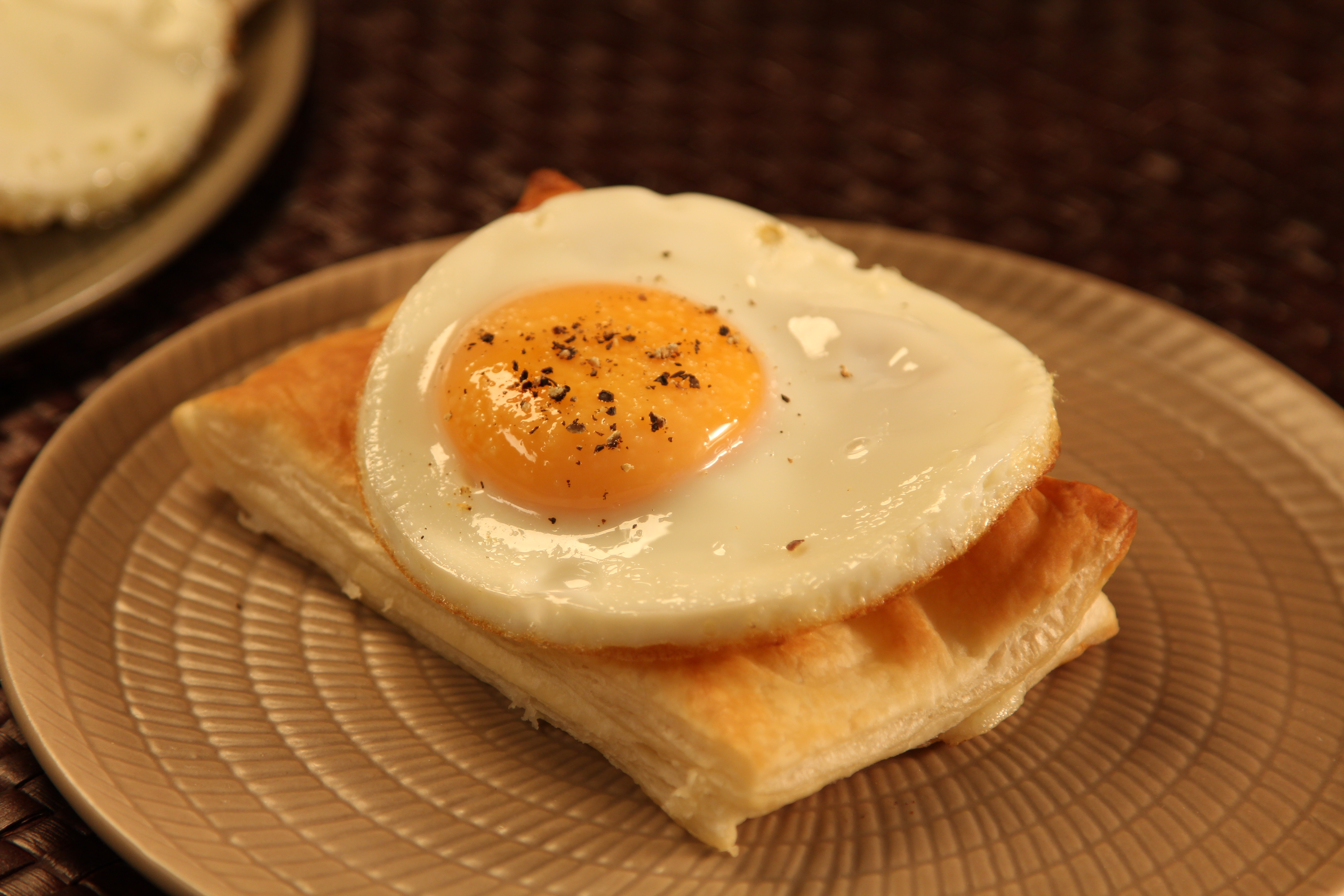 Bikini de hojaldre, jamón y queso con huevo plancha