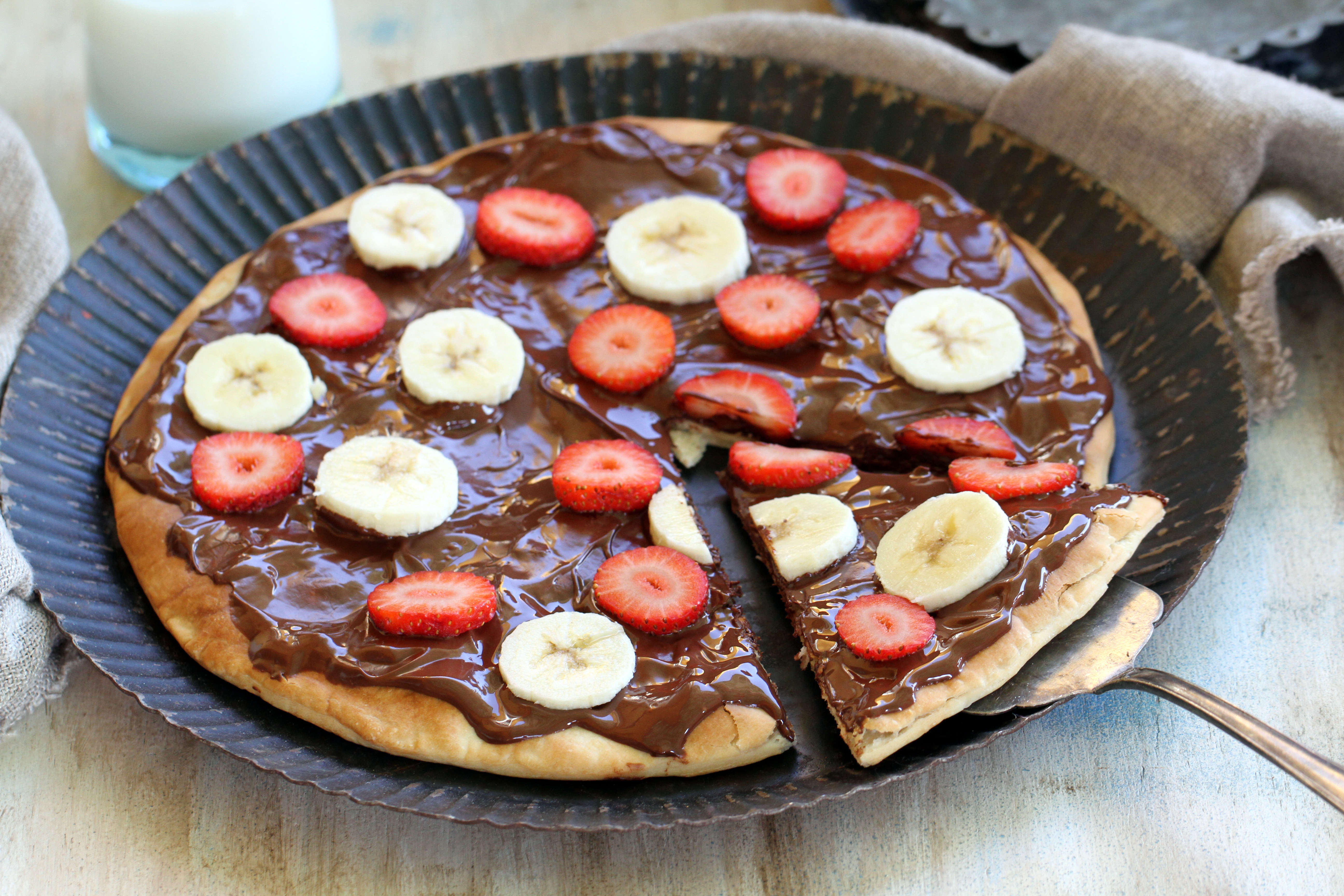 Pizza de chocolate con fresones y plátanos