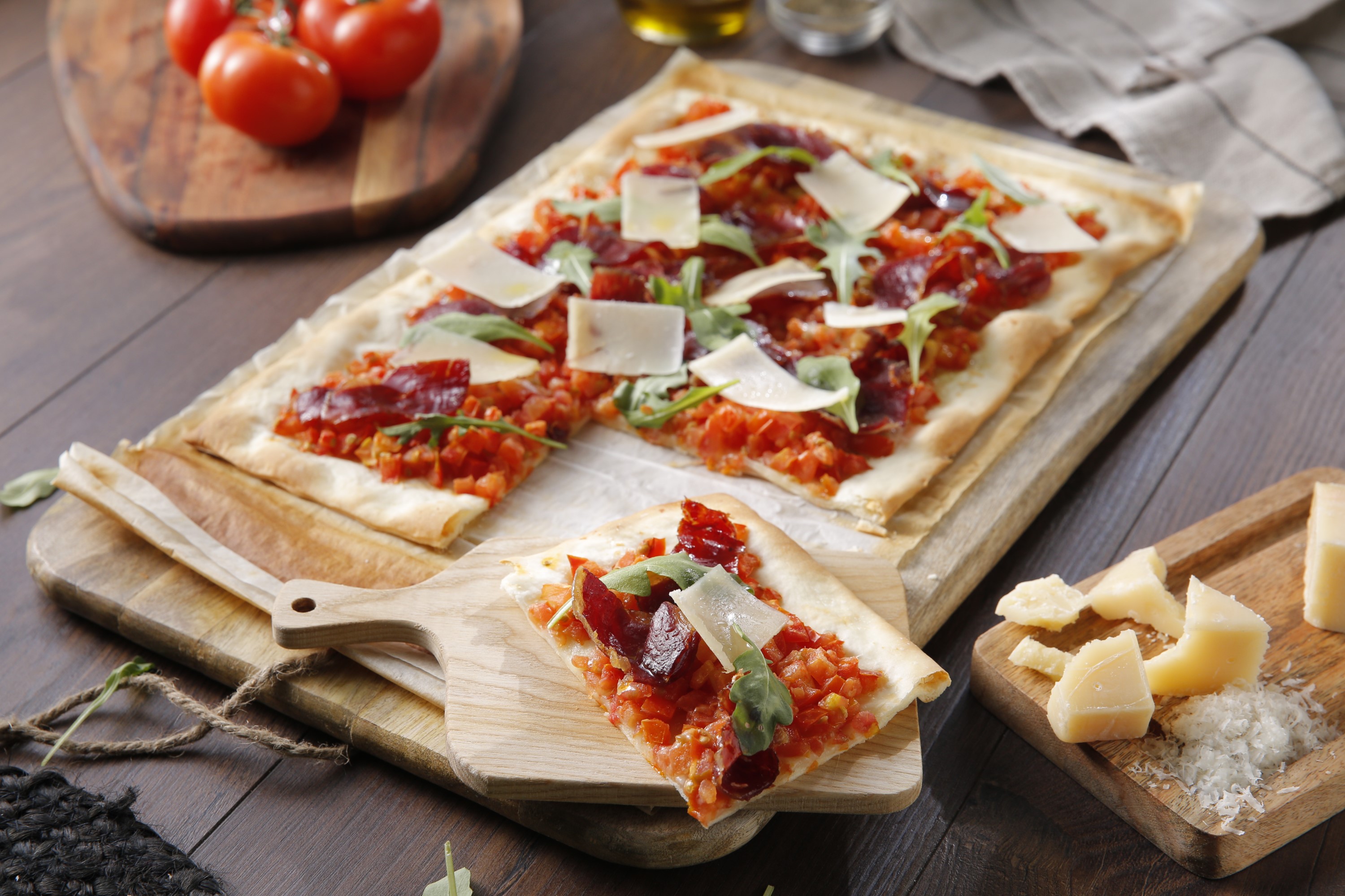 Pizza de jamón ibérico y tomate con rúcula y parmesano