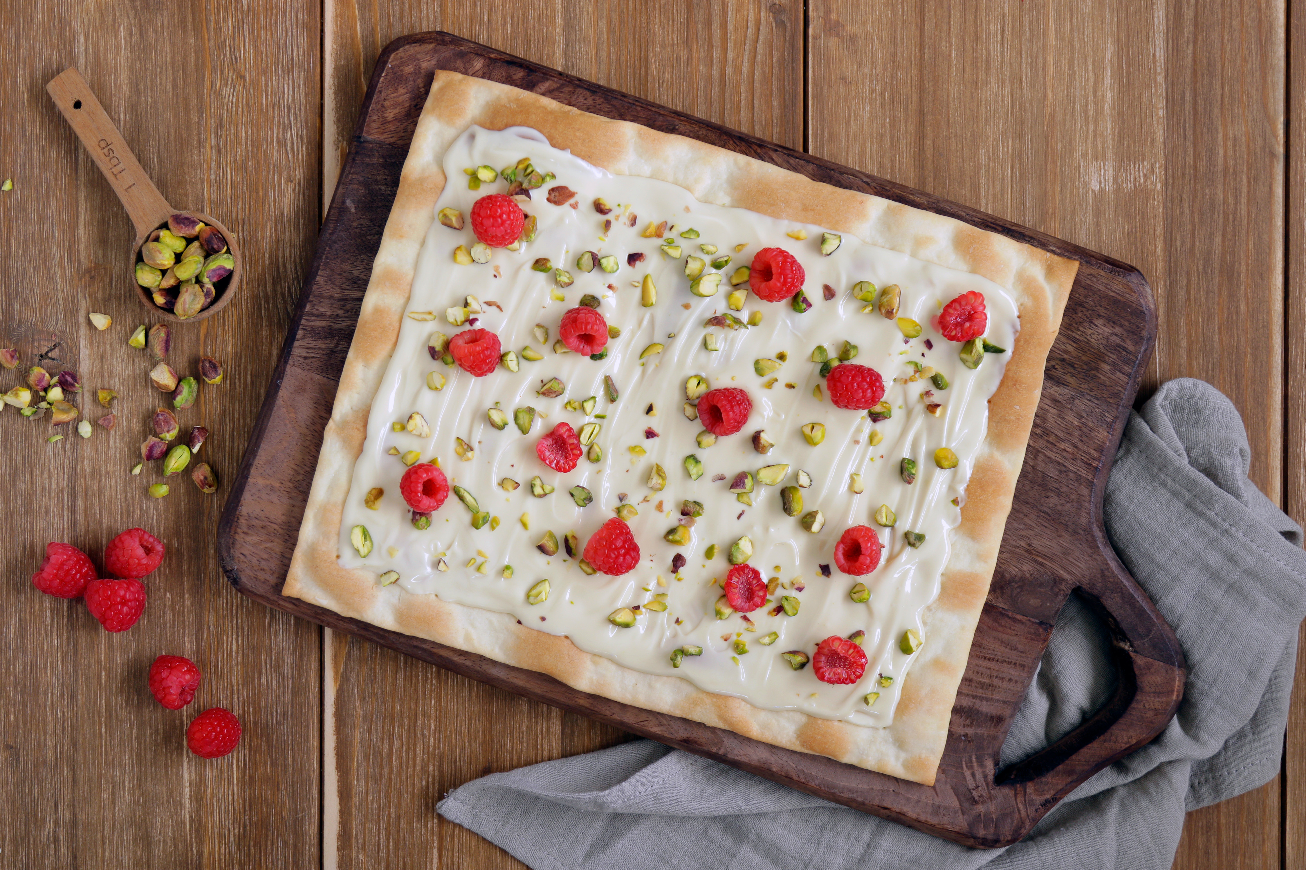 Pizza de chocolate blanco con frambuesas y pistachos