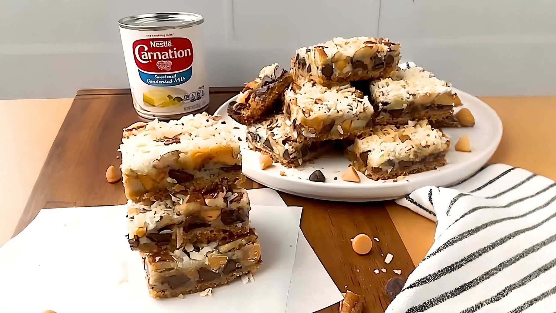 Barras dulces con nueces y caramelo apiladas junto a lata de leche condensada