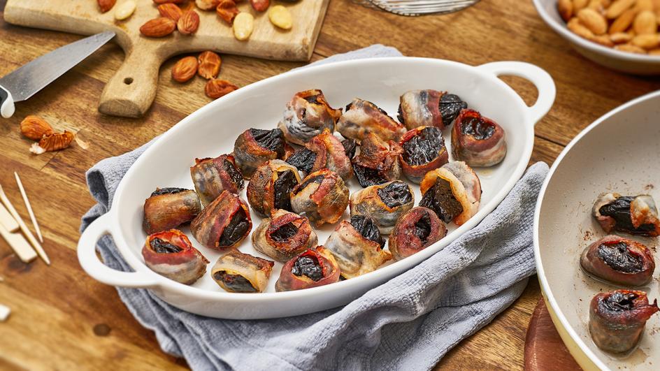 Mit Mandeln gefüllte Pflaumen im Speckmantel