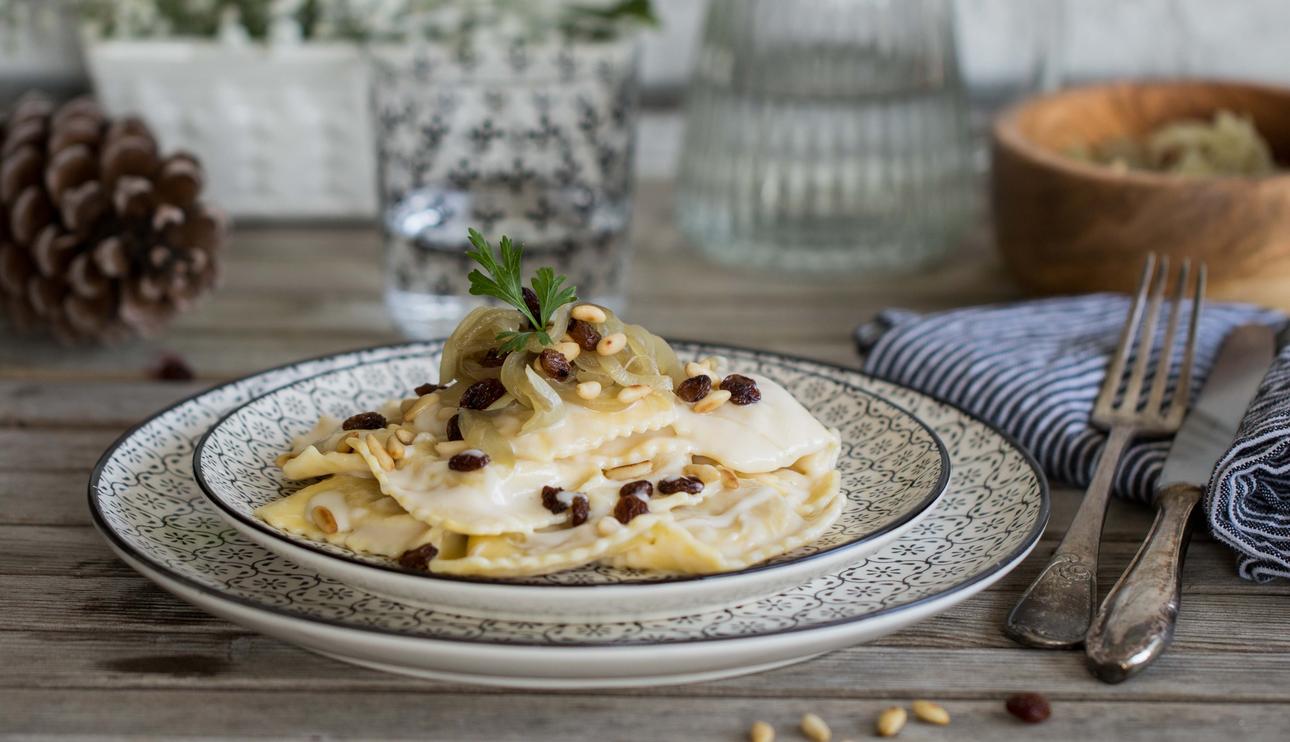Ripieni cremosi ravioli de gorgonzola y almendras y salsa de queso, pasas y piñones