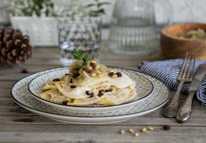 Ripieni cremosi ravioli de gorgonzola y almendras y salsa de queso, pasas y piñones