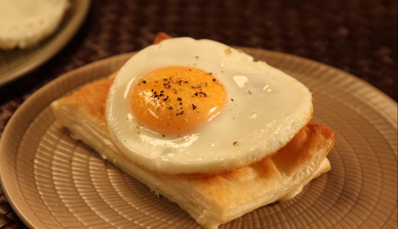 Bikini de hojaldre, jamón y queso con huevo plancha