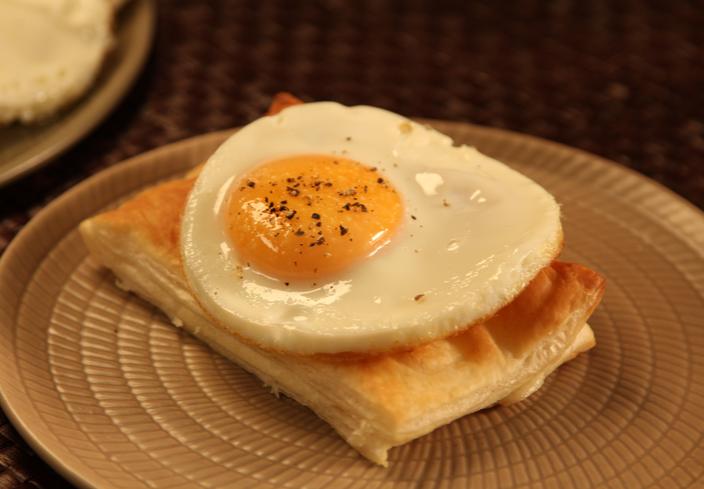 Bikini de hojaldre, jamón y queso con huevo plancha