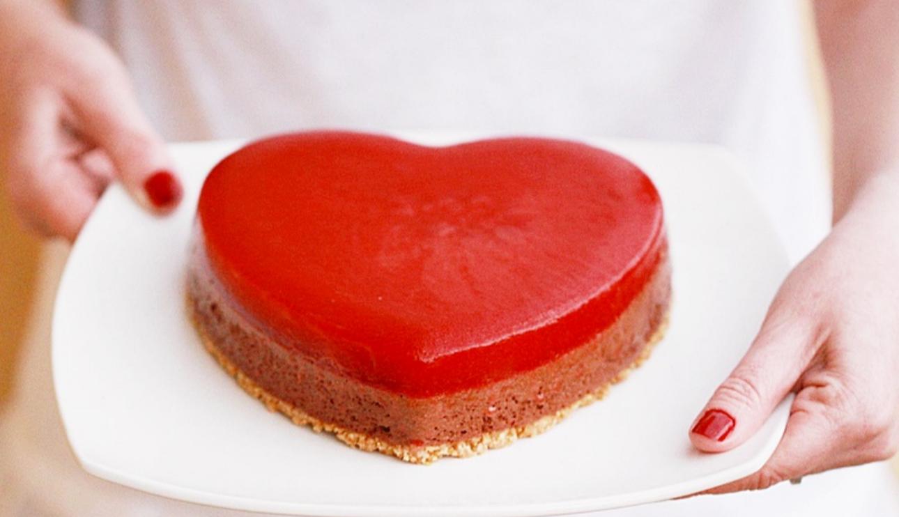 Pastel corazón de mousse de chocolate y coulis de fresas