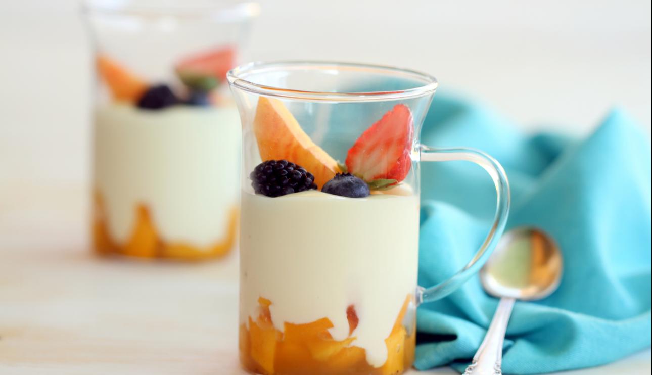 Vaso de crema de chocolate blanco y mascarpone con melocotones