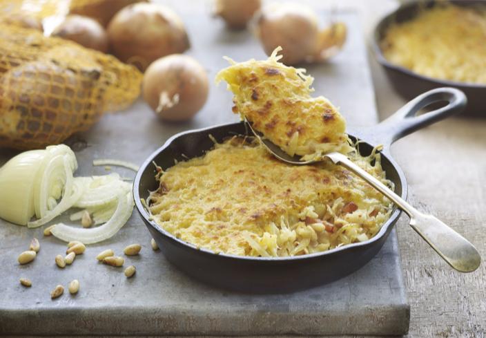 Gratén de patatas con cebolla, beicon con piñones y queso