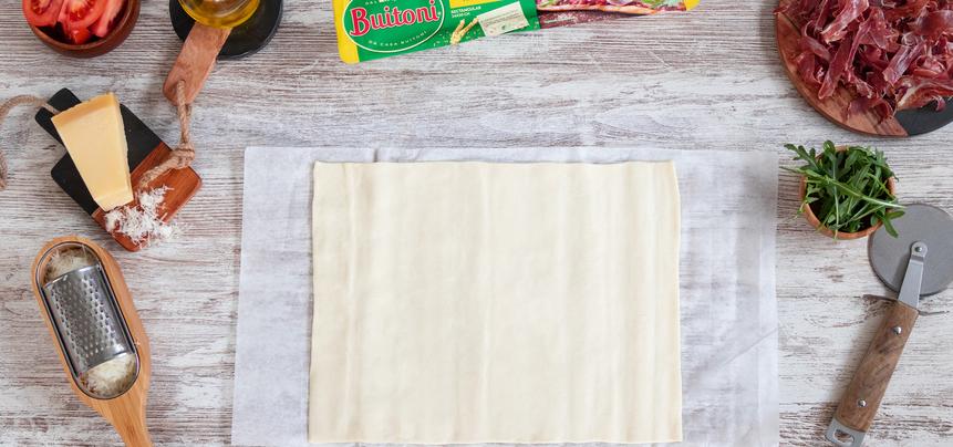 Pizza de jamón ibérico y tomate con rúcula y parmesano