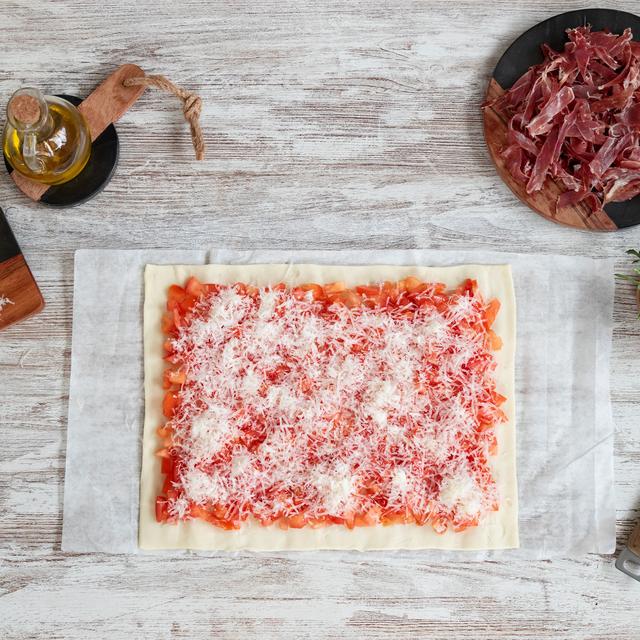 Pizza de jamón ibérico y tomate con rúcula y parmesano