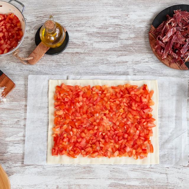 Pizza de jamón ibérico y tomate con rúcula y parmesano