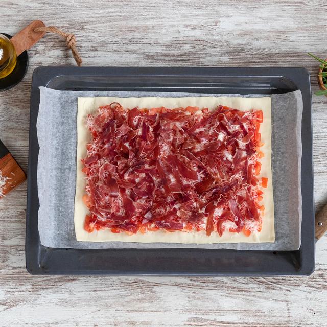Pizza de jamón ibérico y tomate con rúcula y parmesano