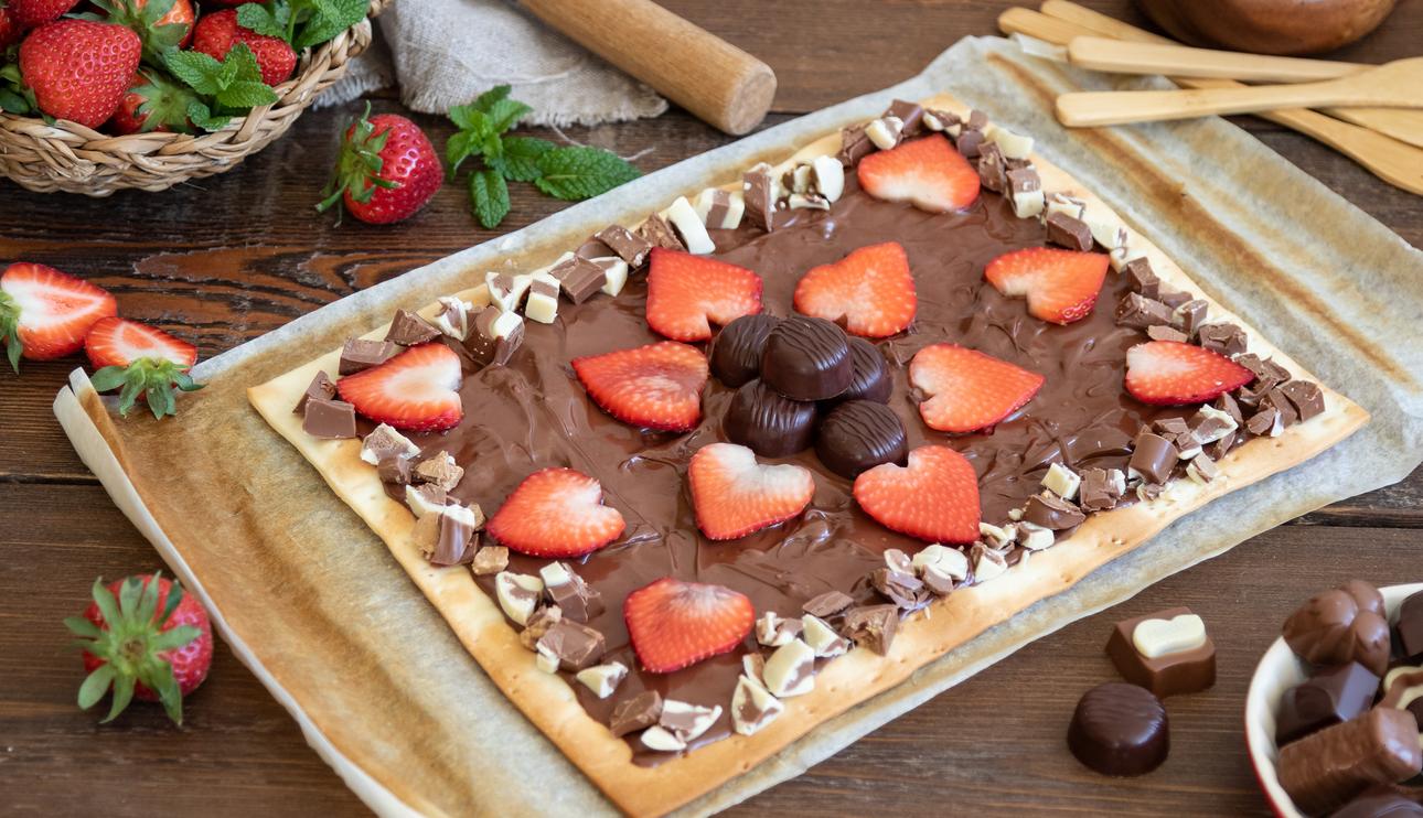 Pizza de chocolate con leche,  bombones y fresas