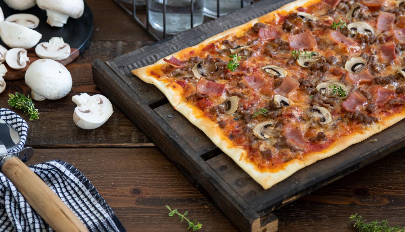 Pizza con champiñones, carne picada y beicon