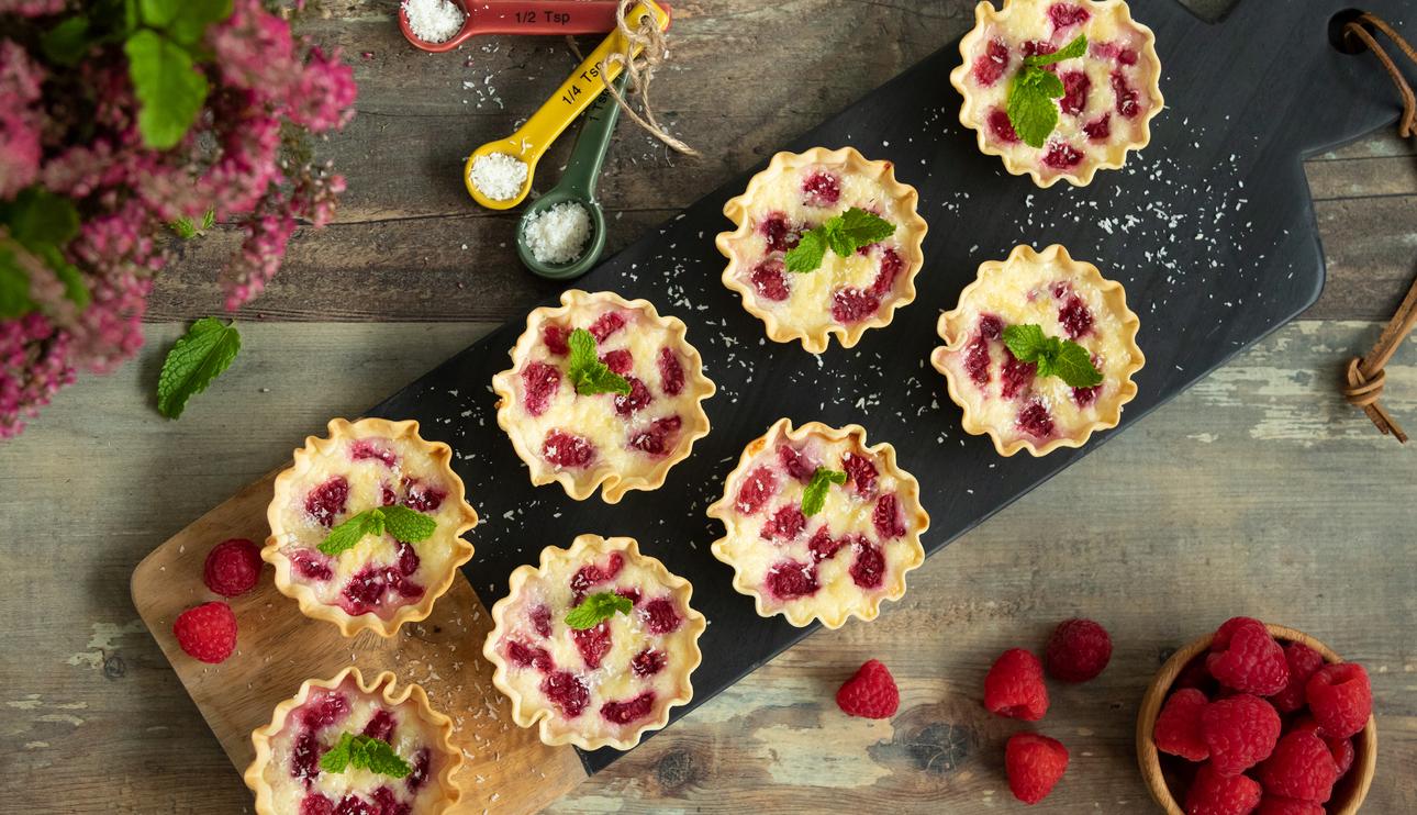 Tartaletas rellenas de queso crema con coco y frambuesas