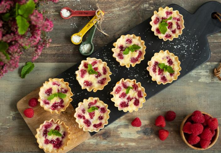 Tartaletas rellenas de queso crema con coco y frambuesas