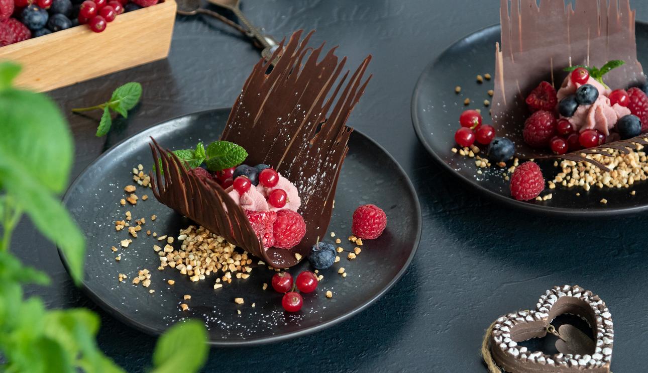 Postre de chocolate negro y blanco con frutos rojos para San Valentín