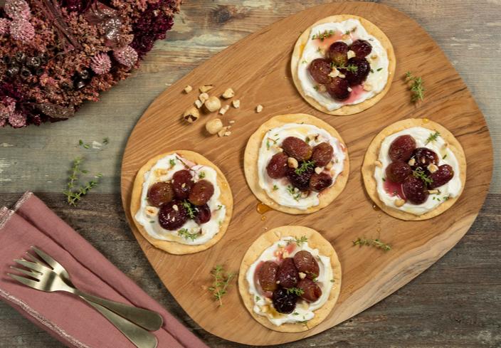 Montaditos de cremoso de queso con uvas asadas, miel y tomillo