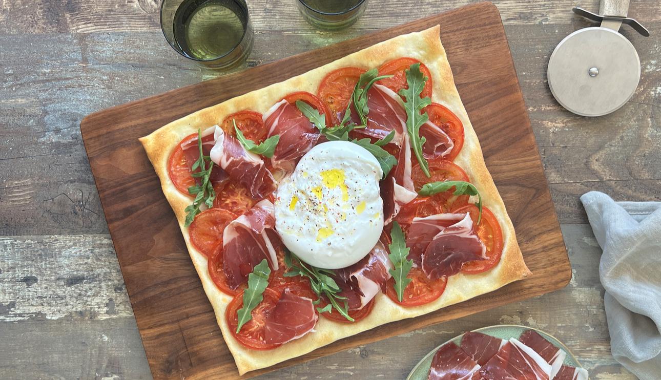 Pizza de jamón y tomate con burrata