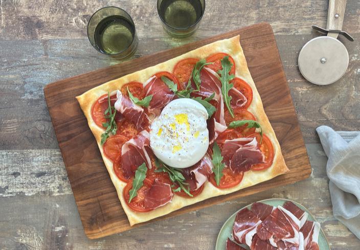 Pizza de jamón y tomate con burrata