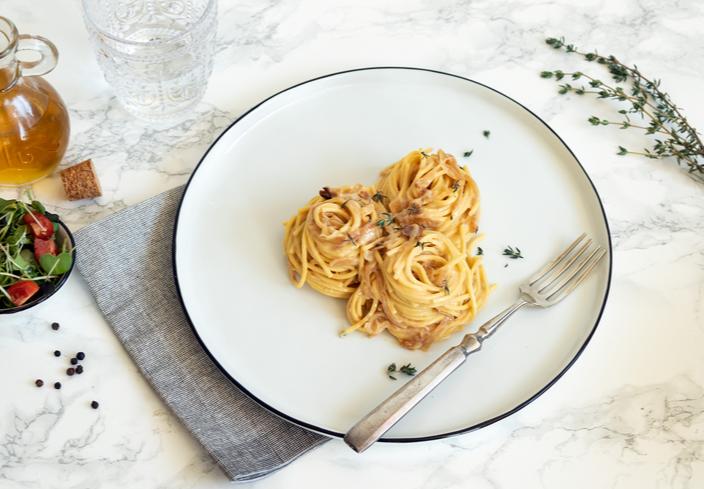 Spaghetti con salsa cremosa de cebolla caramelizada