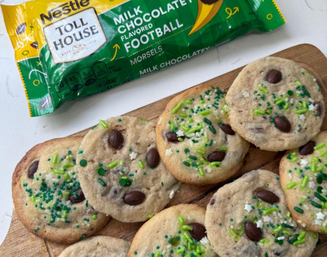 NESTLÉ® TOLL HOUSE® Football Sugar Cookies, decorated with milk chocolatey football morsels, on a white plate.