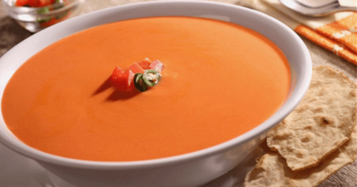Pico de Gallo Cream Soup with NESTLÉ® CARNATION® Milk, topped with fresh pico de gallo, served in a white bowl.