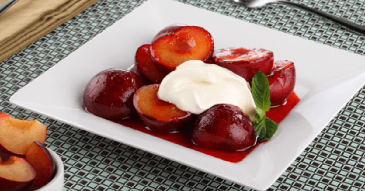 Caramelized plums with NESTLÉ® Media Crema, served on a white dish.