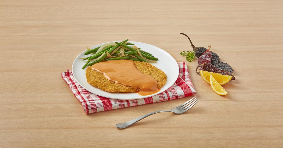 Chicken Milanese in creamy orange sauce with crispy cutlets, NESTLÉ® Media Crema, and MAGGI® Bouillon.