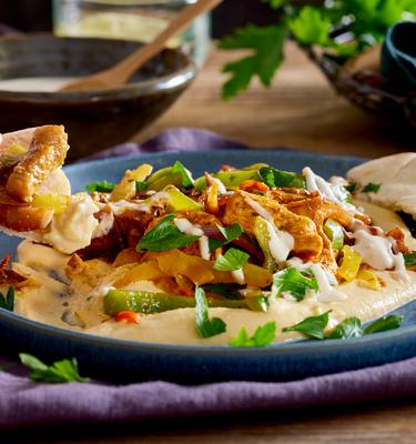 Orientalisches Hähnchen mit Gemüse auf Hummus